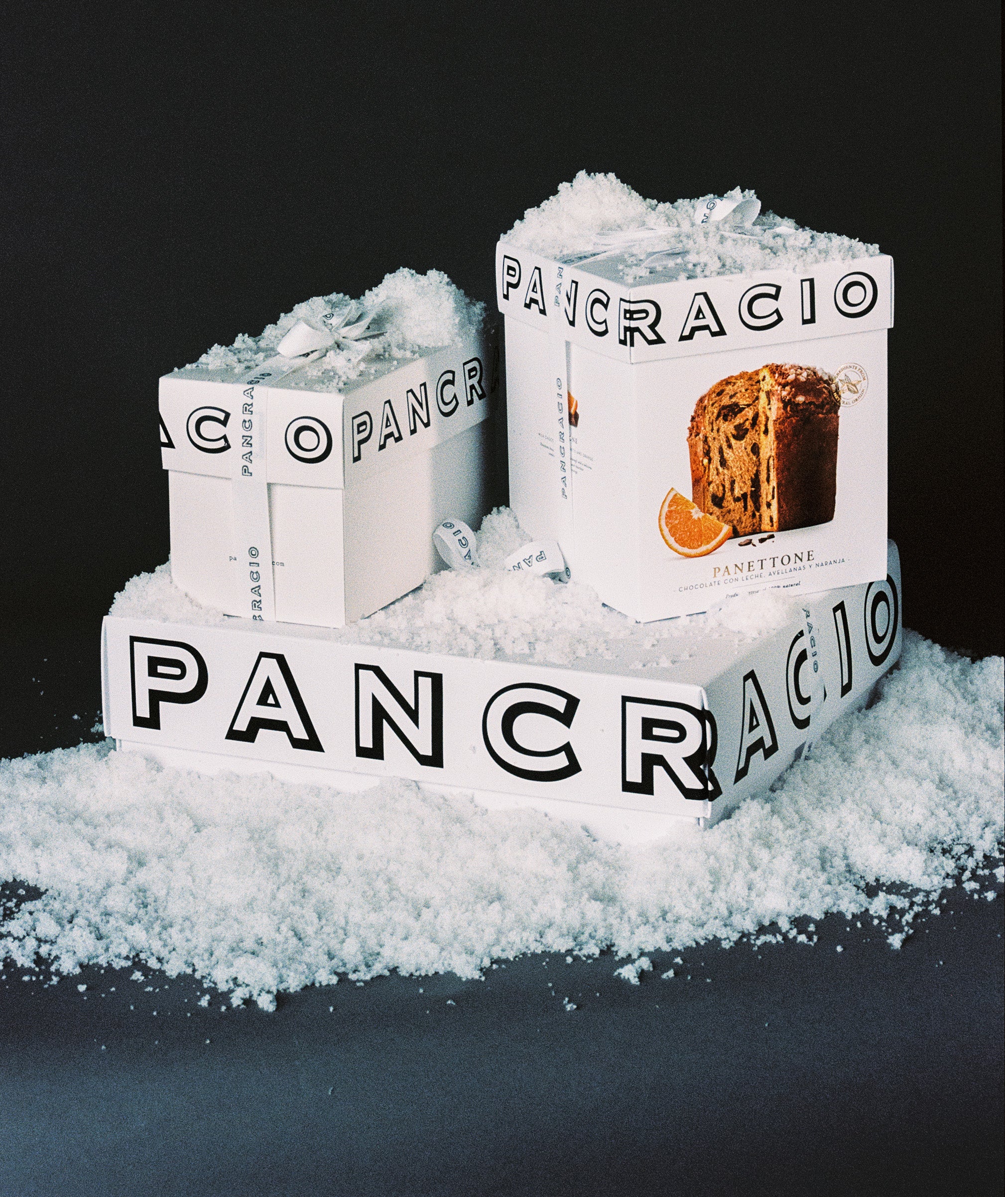 Imagen de un panettone de naranja Pancracio junto a otras cajas de la marca, todas cubiertas de hielo